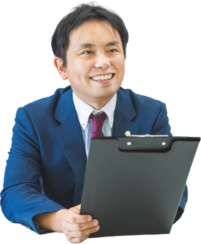 クリップボードを手に笑顔を見せる代表理事 佐々木良道